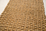Braided texture of the gold hand woven mat, showing natural hemp and jute.