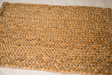 Textured hand braided surface of the golden hemp, jute, and sisal mat.