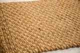Textured hand-braided weave of the golden natural fiber mat.
