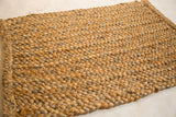 Golden-brown braided texture of the durable natural fiber entrance mat.