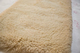 Plush, hand woven shag texture in a creamy beige hue on the bath mat.