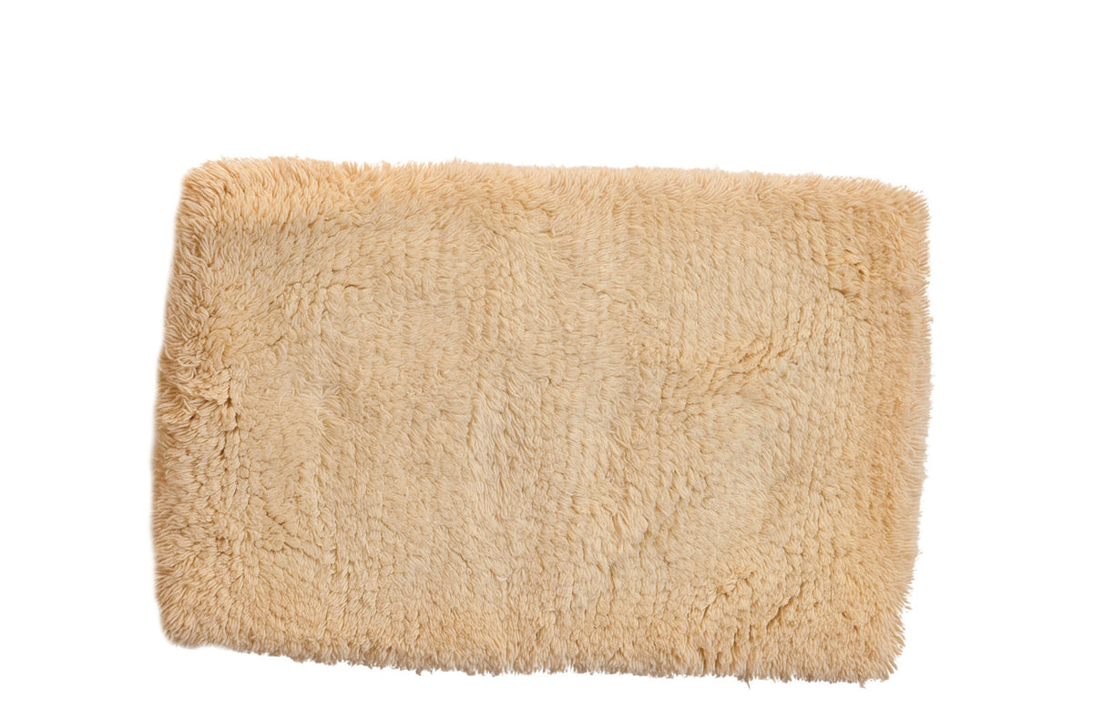 Hand woven Moroccan shag bath mat with plush, light beige texture, 2' x 3'1".