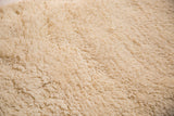 Plush hand-woven cream shag texture of the bath mat.
