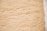 Plush, neutral hand-woven shag pile texture of the Moroccan bath mat.