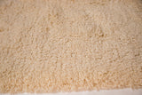 Plush hand woven shag pile texture in soft creamy beige.