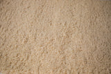 Plush, hand woven Moroccan shag bath mat with soft, textured cream pile.