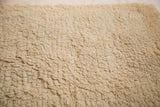 Plush cream shag pile of the hand-woven Moroccan bath mat.