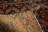 Hand-knotted foundation and fringe of an antique Malayer rug, showing its woven beige, red, yellow threads.