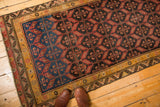 Antique Malayer rug with geometric pattern transitioning from deep blue to rich black, red motifs.
