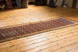 Secured end of the circa 1920s antique Persian Malayer runner, with deep blue and rust palette.