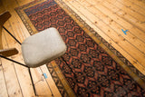 Tribal geometric pattern in red and black on the antique Malayer runner.