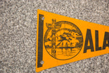 Detail of vintage orange felt Alaska flag, showing totem pole graphic.