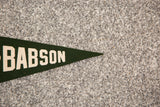 Pointed tip of the vintage green Babson felt flag with white lettering.