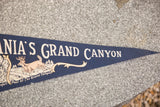 Pointed tip of vintage navy felt banner showing 'GRAND CANYON' text and deer detail.