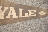 Aged cream 'ALE' lettering and football graphic on a vintage brown felt flag.