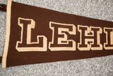 Layered beige LEHI lettering on textured brown felt of the vintage banner.