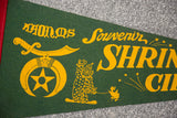 Yellow Shriner emblem, clown, and scimitar graphics on a vintage green felt souvenir flag.