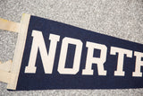Cream 'NORTH' lettering on navy blue felt, vintage North Penn banner with stitched edge.
