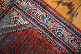 Distressed red rust field and ornate mirror Serbend border of a vintage Mir Serbend rug.