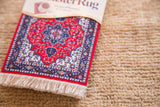 Heriz CoasterRug with ornate cherry red field, blue medallion, and white fringe detail.