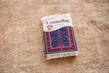 Packaged CoasterRug, a miniature traditional blue and red Oriental design.