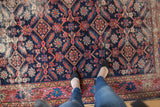Distressed antique Malayer rug field, indigo Herati pattern, blush red serrated leaves, saffron accents.