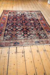 Secured hand-knotted fringe and patterned border of this antique distressed Malayer rug.