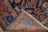 Distressed antique Malayer rug pile, folded, with Herati motifs, fringe, indigo, blush, teal.
