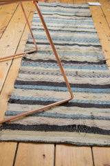 Distressed texture of vintage Scandinavian rag rug, showing varied blue, ivory, and charcoal stripes.