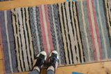 Hand woven vintage Scandinavian rag rug detail with varied vertical stripes in ivory, blue, and blush.