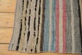 Faded horizontal stripes and visible textural abrashes in pink, blue, ivory, and grey.