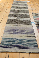 Texture of hand woven Scandinavian rag rug with blue, teal, and ivory stripes.