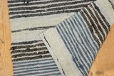 Folded vintage Scandinavian rag rug showing hand-woven texture and blue and charcoal stripes.