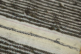 Hand-woven texture of vintage Scandinavian rag rug with varying charcoal and ivory stripes.