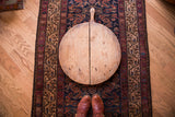 Vintage wooden pizza board with hand-hewn nails and rich wood patina.