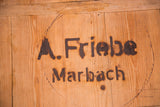 Dark stenciled 'A. Friebe Marbach' text with rustic wood grain and aged patina.