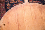 Close-up of vintage wooden pizza board's natural wood grain, rustic patina, and hanging hole.