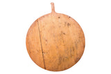 Vintage wooden pizza board with hand-hewn texture, vertical crack, and rich patina.