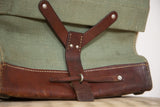 Brown leather Y-strap closure with metal rivets on vintage Swiss Army green canvas.