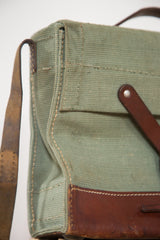 Sturdy green canvas, brown leather, and prominent stitching detail of the Swiss Army bag.