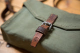 Brown leather buckle and strap with Swiss mark on vintage army bag.