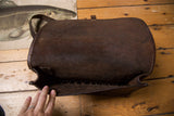 Worn dark brown leather interior of vintage messenger bag showing internal loops.