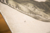 Aged beige paper of the vintage school chart, revealing subtle creases and a handwritten letter 'a'.