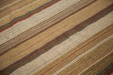 Coarse wool weave of the New Kilim carpet, highlighting varied earthy stripes and thin red lines.