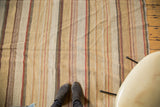 Hand woven Kilim carpet with textured vertical stripes in mustard, ivory, and red.