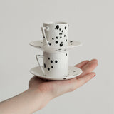 Stacked handmade modern espresso cup set featuring black speckle pattern on white.