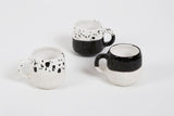 Three handmade modern coffee mugs featuring speckled black and white designs.