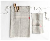 Two handmade linen short aprons, light grey, with striped pockets, one folded.