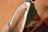 A view inside the heirloom stocking, showing the soft off-white fabric lining and green suede cuff.