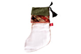 Ivory heirloom stocking, olive suede cuff, multi-color geometric antique rug fragment.